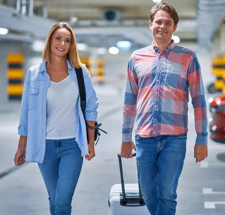 Couple With Baggage In Parking Lot Traveling To The Airport